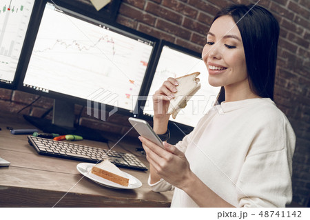 Time for lunch. Happiness woman eating sandwich, using smart phone Time for lunch. Happiness woman eating sandwich, using smart phone 48741142