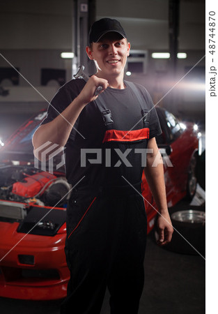 Mecanic in front of the red car. Mecanic in front of the red car. 48744870