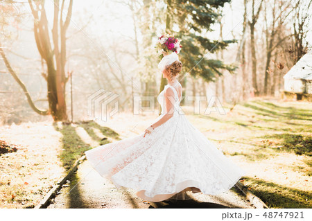 Beautiful bride spinning with perfect dress in the park Beautiful bride spinning with perfect dress in the park 48747921