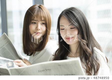 窓辺で新聞を読む女性二人 48748950