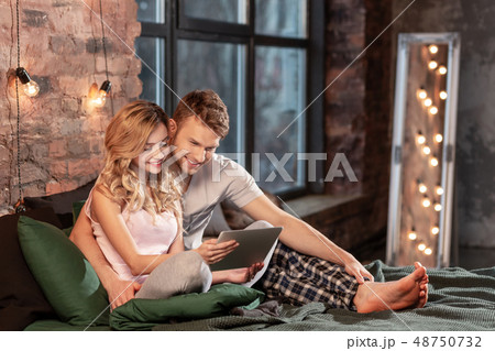 Beaming couple spending happy cozy time together in the bedroom 48750732