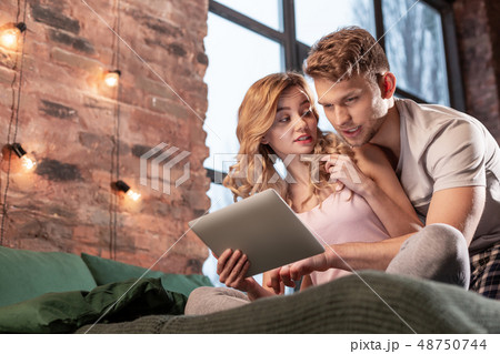 Just married couple searching the place for dinner in the Internet using tablet 48750744