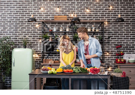 Blonde-haired woman with wavy hair enjoying cooking time with her man 48751390