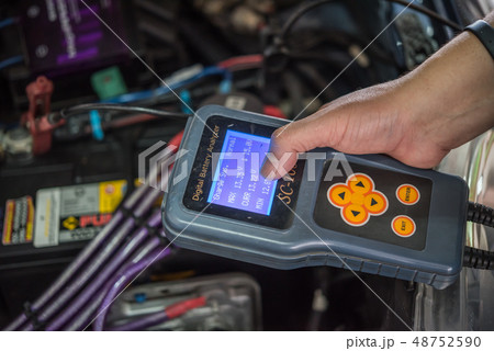 Checking a car battery for repair at car garage Checking a car battery for repair at car garage 48752590