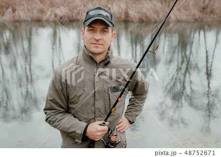 Young man standing with fishing rod 48752671