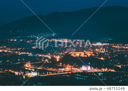 Gori, Shida Kartli Region, Georgia. Gori Fortress In Cityscape In Evening Illumination Under Blue 48755249