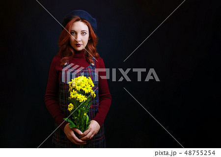 Woman holds a yellow chrysanthemum Woman holds a yellow chrysanthemum 48755254