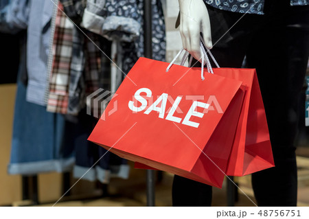 Part of male mannequin dressed in casual clothes holding the Sales paper shopping bag in the shopping department store for shopping, business fashion and advertisement concept 48756751