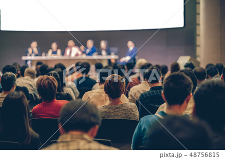 Rear view of Audience in the conference hall or seminar meeting which have Speakers are Brainstorming and talking on the stage, business and education about investment concept 48756815