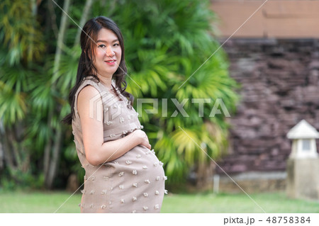 pregnant woman resting in garden 48758384