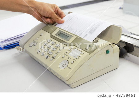 hand man are using a fax machine in the office hand man are using a fax machine in the office 48759461