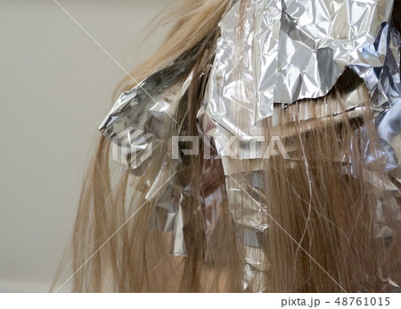 Foil on the hair when coloring the hair. Foil on the hair when coloring the hair. 48761015