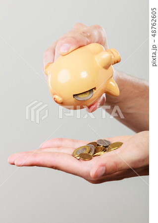 Male hands with coins and piggybank Male hands with coins and piggybank 48762605