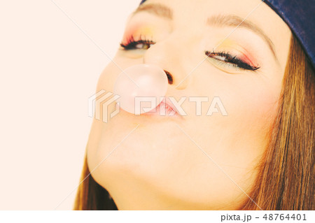 Funky girl making balloon. 48764401