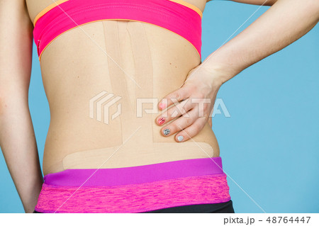 Woman with medical kinesio taping on back Woman with medical kinesio taping on back 48764447