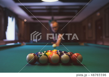 Young man playing billiard indoors.   48765596