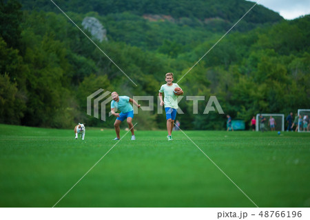 Father and son are running in park with dog Father and son are running in park with dog 48766196