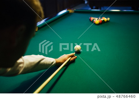 American billiard. Man playing billiard, snooker. Player preparing to shoot, hitting the cue ball. 48766460
