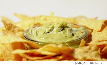 Tortilla chips and guacamole dip on the plate, close-up shot Tortilla chips and guacamole dip on the plate, close-up shot 48766578