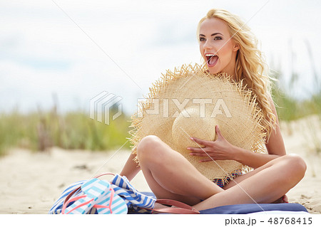 Naked woman on the beach holding summer  hat 48768415