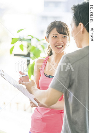 ヨガスタジオで美女インストラクターから説明を受ける若い男性会社員細マッチョ 48768451
