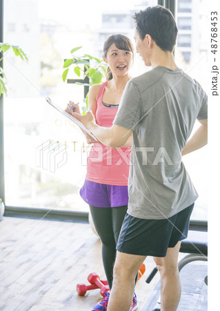 パーソナルジムで美女インストラクターから筋トレーニングの説明を受ける若い男性会社員細マッチョ パーソナルジムで美女インストラクターから筋トレーニングの説明を受ける若い男性会社員細マッチョ 48768453