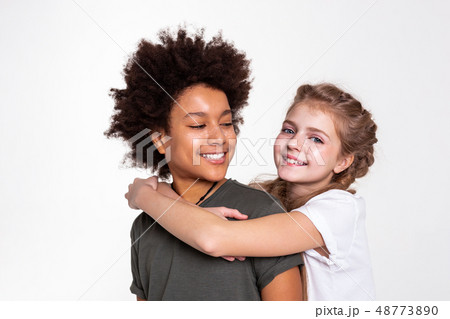 Pleasant dark-haired boy with wild hairstyle looking on his girlfriend Pleasant dark-haired boy with wild hairstyle looking on his girlfriend 48773890