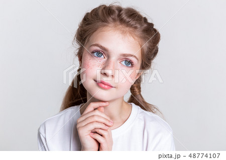 Pleasant sinless little child looking up with her big eyes Pleasant sinless little child looking up with her big eyes 48774107
