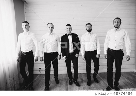 Handsome groom with his groomsman at home. Five man. Groom dressed in suit, gromsmen in white shirt 48774484