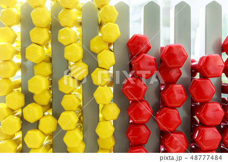 A lot of colorful dumbbell on stand 48777484