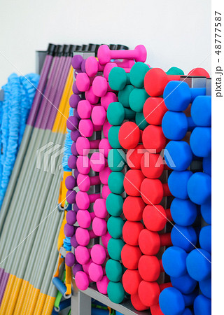 A lot of colorful dumbbell on stand A lot of colorful dumbbell on stand 48777587