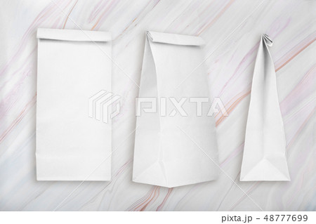 Blank white paper bags on marble texture with natural pattern. Lunch paper bags 48777699