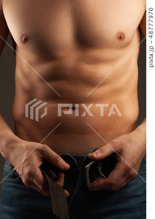 Man unbuckling the belt. Abdominal muscles  48777970