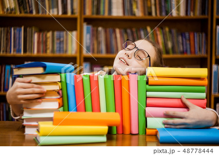 The girl in glasses in the library hugs books The girl in glasses in the library hugs books 48778444