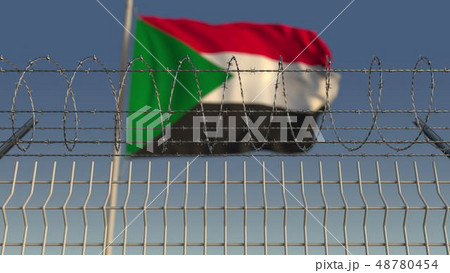 Defocused waving flag of Sudan behind barbed wire fence. 3D rendering Defocused waving flag of Sudan behind barbed wire fence. 3D rendering 48780454