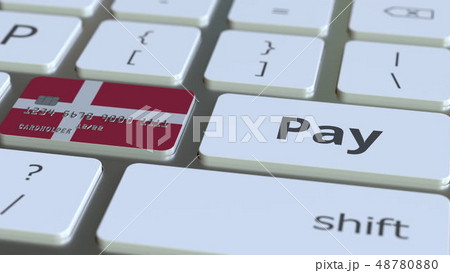 Bank card featuring flag of Denmark as a key on a computer keyboard. Danish online payment 48780880