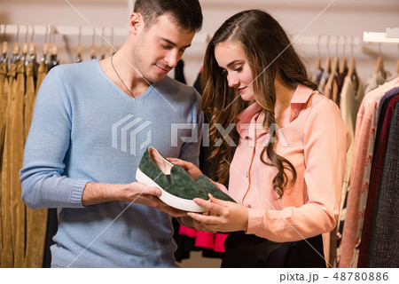 Man and woman buy shoes in store. Man and woman buy shoes in store. 48780886