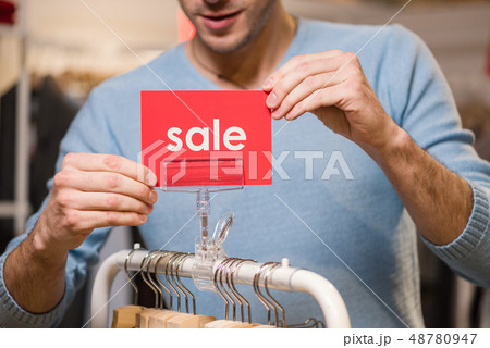 Seller holds red signs with sale word 48780947