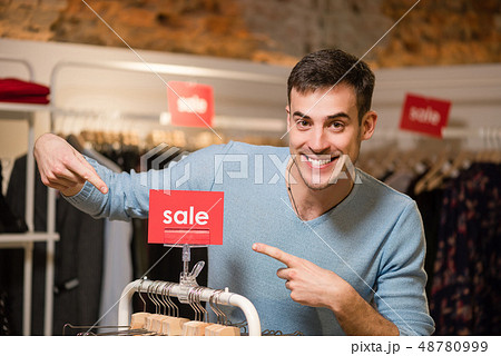 Smiling handsome seller point sale red tag 48780999