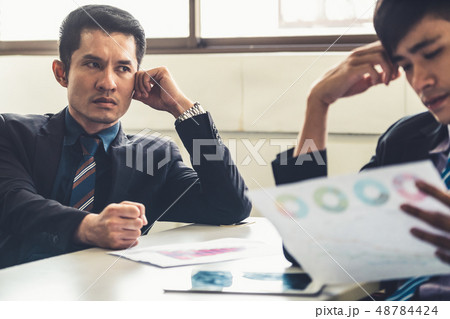 Unhappy business manager and young businessman. 48784424