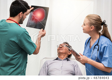 Doctor team work with x ray film image of patient. Doctor team work with x ray film image of patient. 48784643