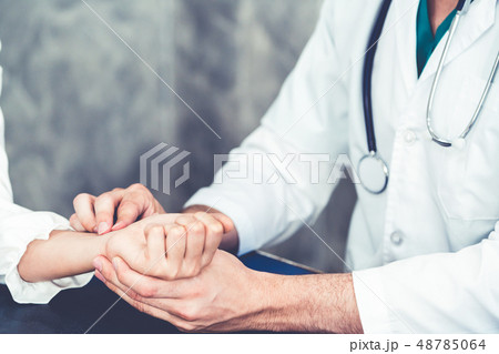 Young doctor examining patient in hospital office. 48785064