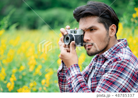 Young hipster man taking photo with retro camera. 48785337