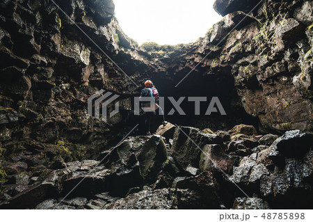 Woman traveler explore lava tunnel in Iceland. 48785898