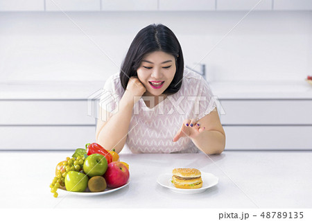 Large girl eating healthy foods and exercise for weight loss, diet concept isolated on gray background 014 48789135
