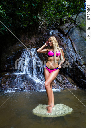 Young woman in oink bikini is posing at waterfall Young woman in oink bikini is posing at waterfall 48790661