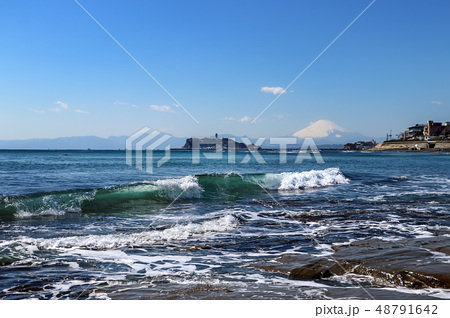 江ノ島と富士山を望む快晴の七里ヶ浜の写真素材