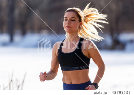 Young woman in top running in cold weather 48795532