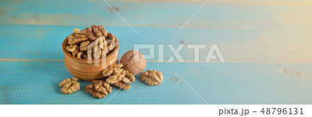 Walnuts on blue rustic table in wooden bowl 48796131