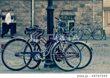 Bicycles are parked to the post in Old Riga Bicycles are parked to the post in Old Riga 48797849